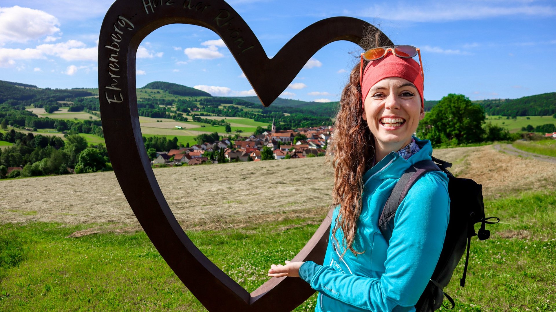 Bloggerin Marlene Vey steht am Selfiepoint und zeigt das Herz der Rhön