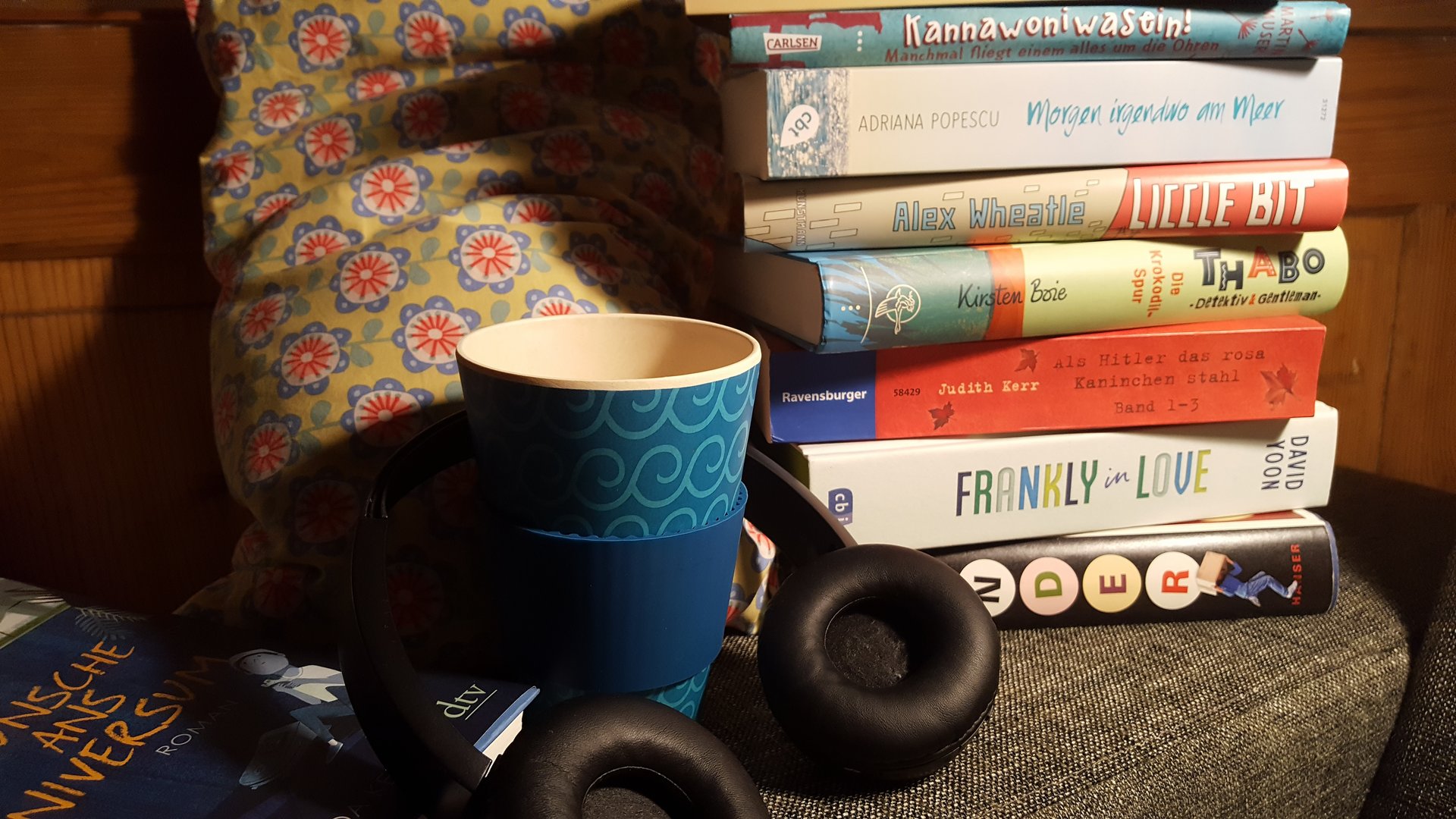 gemütliche Sitzecke mit Büchern, Tasse Kaffee und Süßigkeiten
