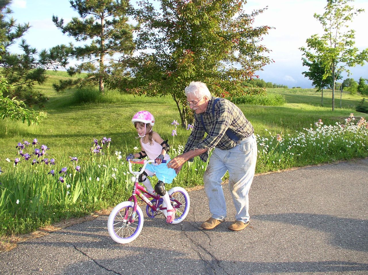 Symbolbild Großvater lernt Enkelin das Fahrradfahren